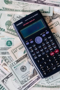 A calculator over a pile of money.